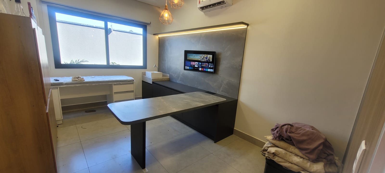 Escritório com painel de pedra e bancada de trabalho