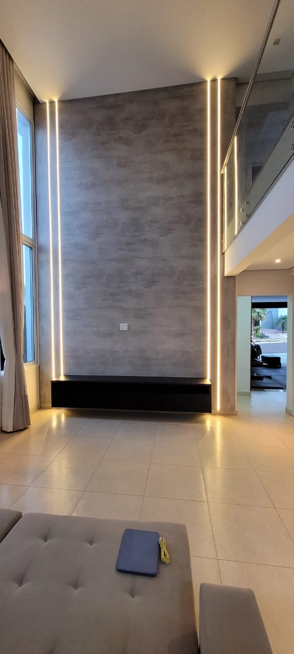 Painel de TV com iluminação LED em sala de pé-direito duplo