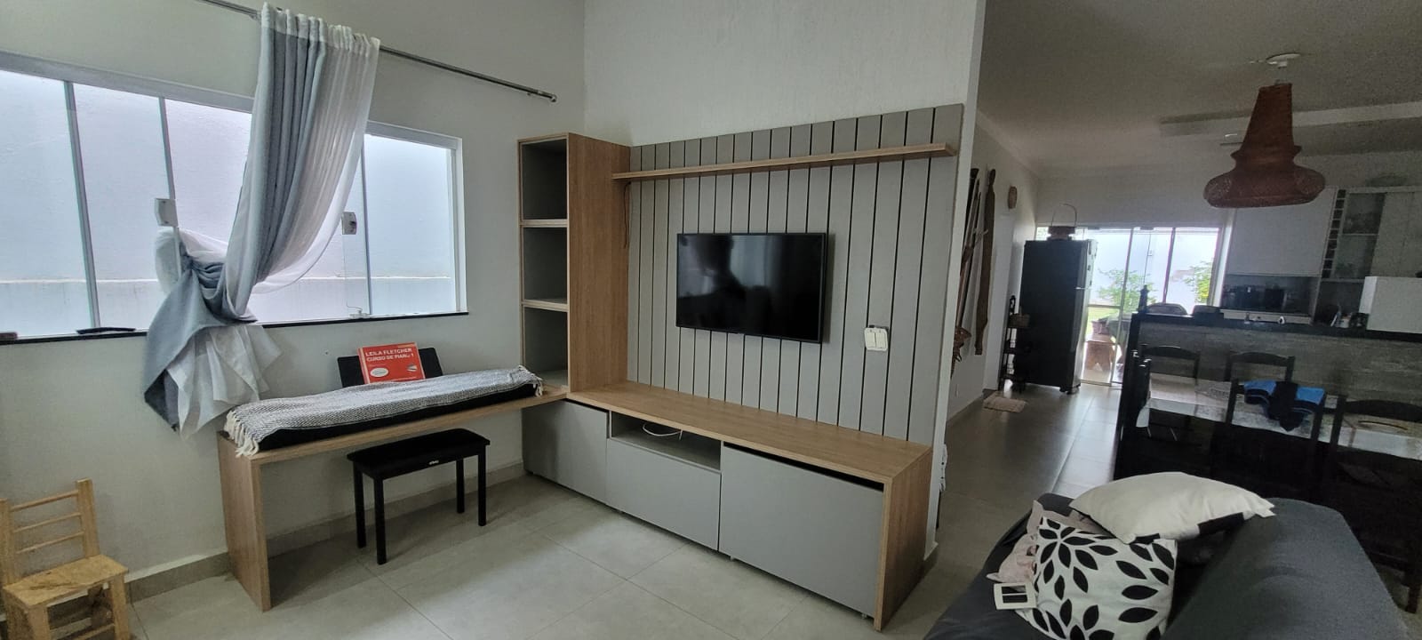 Painel de TV em madeira clara com detalhes ripados